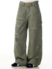 Distressed wide-leg carpenter pants in olive green with a relaxed fit and utility pockets.