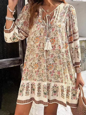 Vibrant floral print mini dress with tassel tie neckline and tiered hem