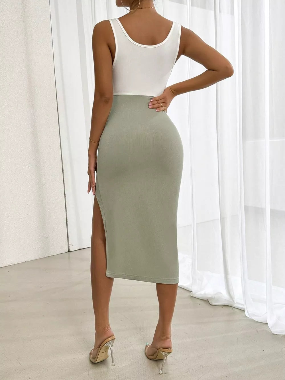 Asymmetrical two-tone midi dress in white and sage green with a high slit and bodycon fit.