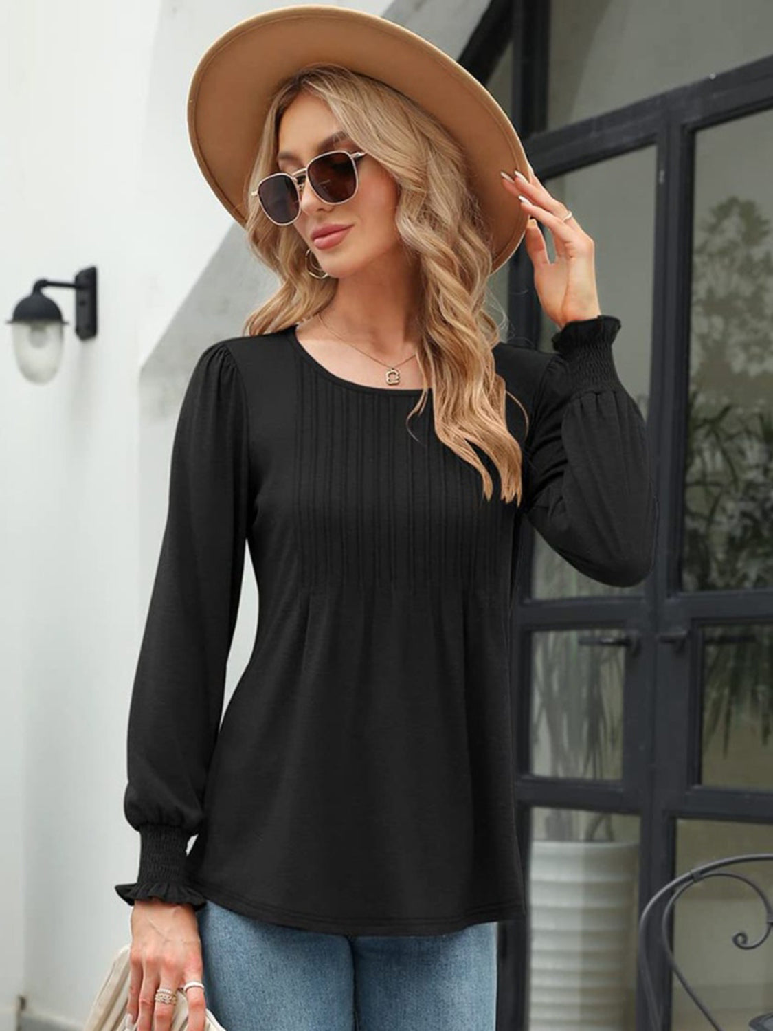 Black long sleeve blouse with pleated bodice and gathered cuffs.