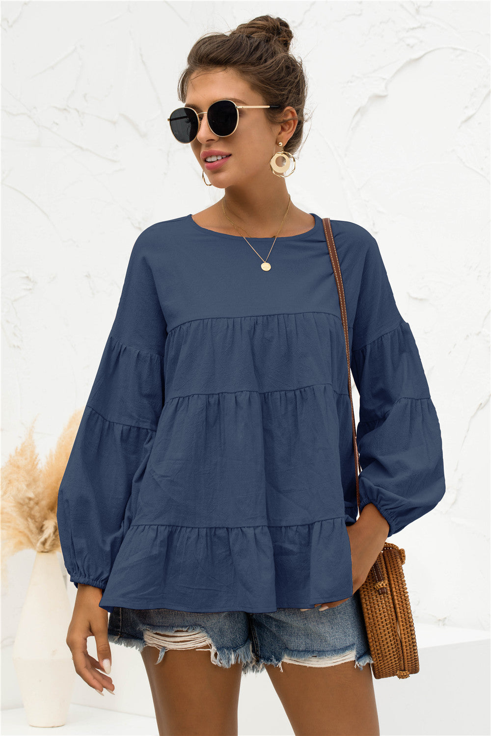 Navy tiered peasant blouse with long balloon sleeves and round neckline.