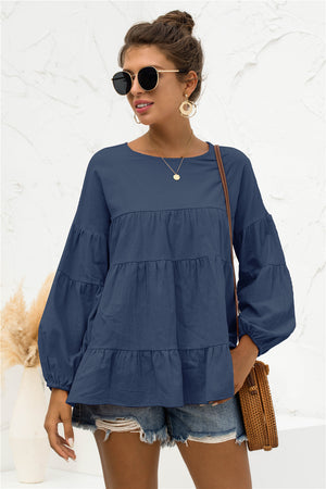 Navy tiered peasant blouse with long balloon sleeves and round neckline.