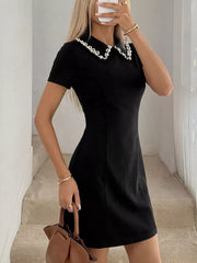 Black a-line mini dress with beaded collar and short sleeves