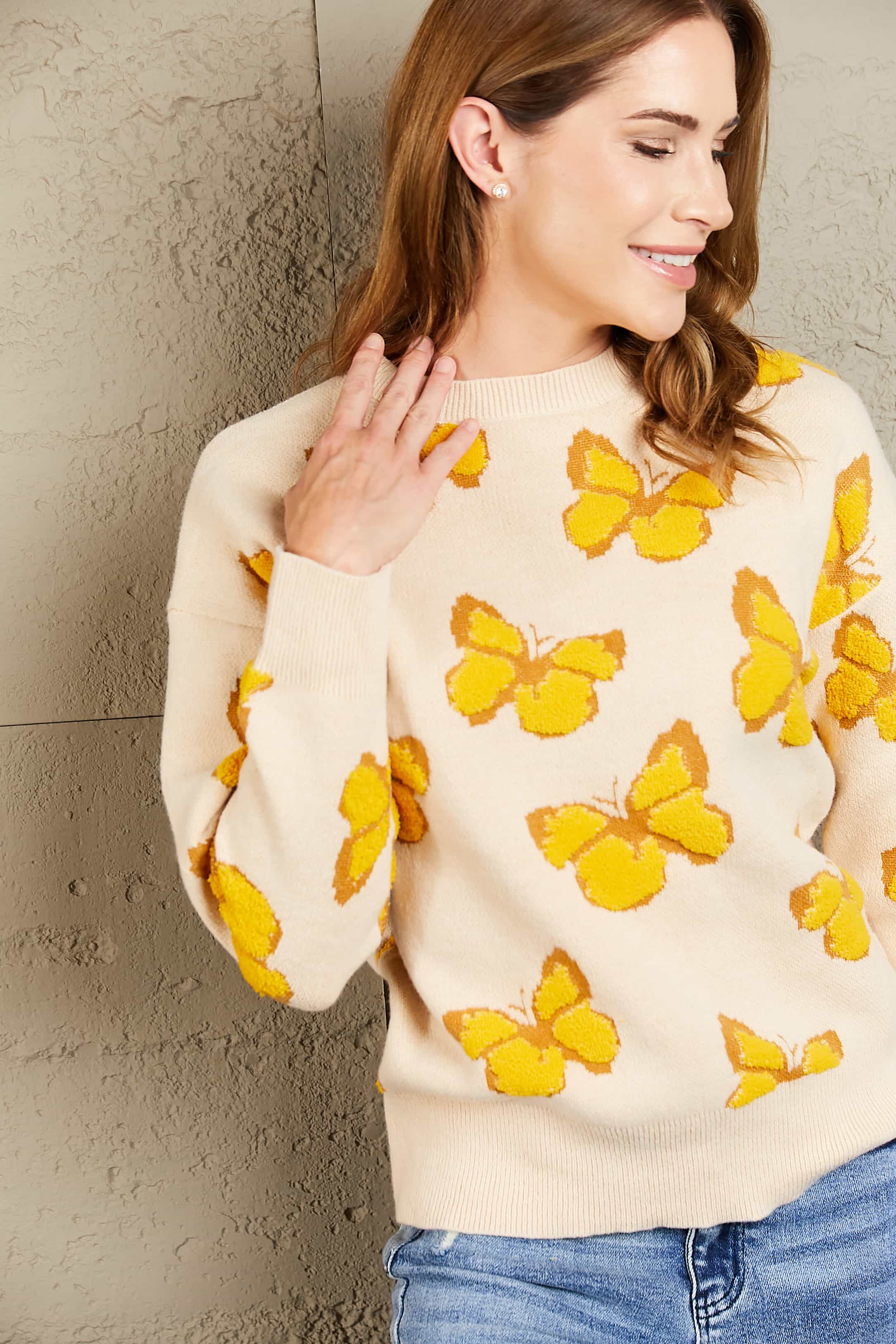 Cream knit crewneck sweater with allover yellow butterfly motif.