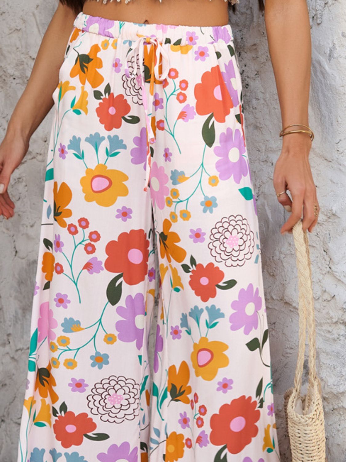 Geometric print wide-leg trousers with drawstring waist in multicolor floral pattern.