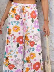 Geometric print wide-leg trousers with drawstring waist in multicolor floral pattern.