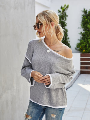 Off-shoulder knit pullover in dark gray with white trim and bell sleeves.