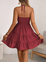 Burgundy ruched halter tiered mini dress with ruffles and a tie back.