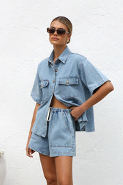 Relaxed light wash denim shirt and drawstring shorts set with button front and chest pockets.