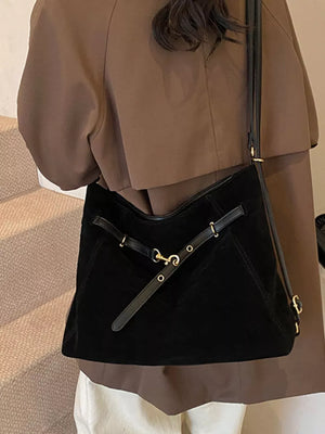 Black suede crossbody bag with gold hardware and adjustable strap