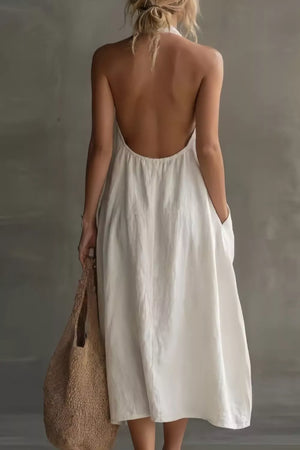 White halter midi dress with pockets and a low open back, shown from behind.