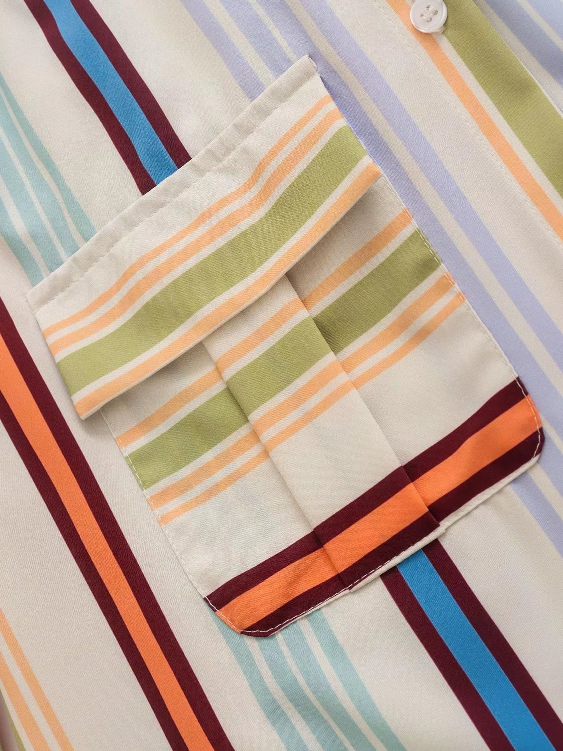Prismatic stripe band collar blouse with buttoned pocket detail.