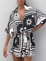 Black celestial print wrap romper with short sleeves and a tie waist.