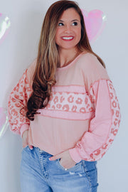 Blush pink waffle knit top with leopard print panels and contrast sleeves.