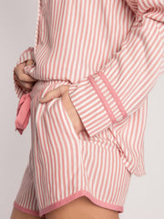 Striped pajama set in pale blush with contrast trim on sleeves and shorts hem.