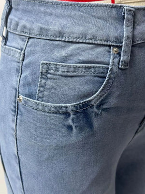 Light wash denim maternity jeans with button closure and wide leg cut.