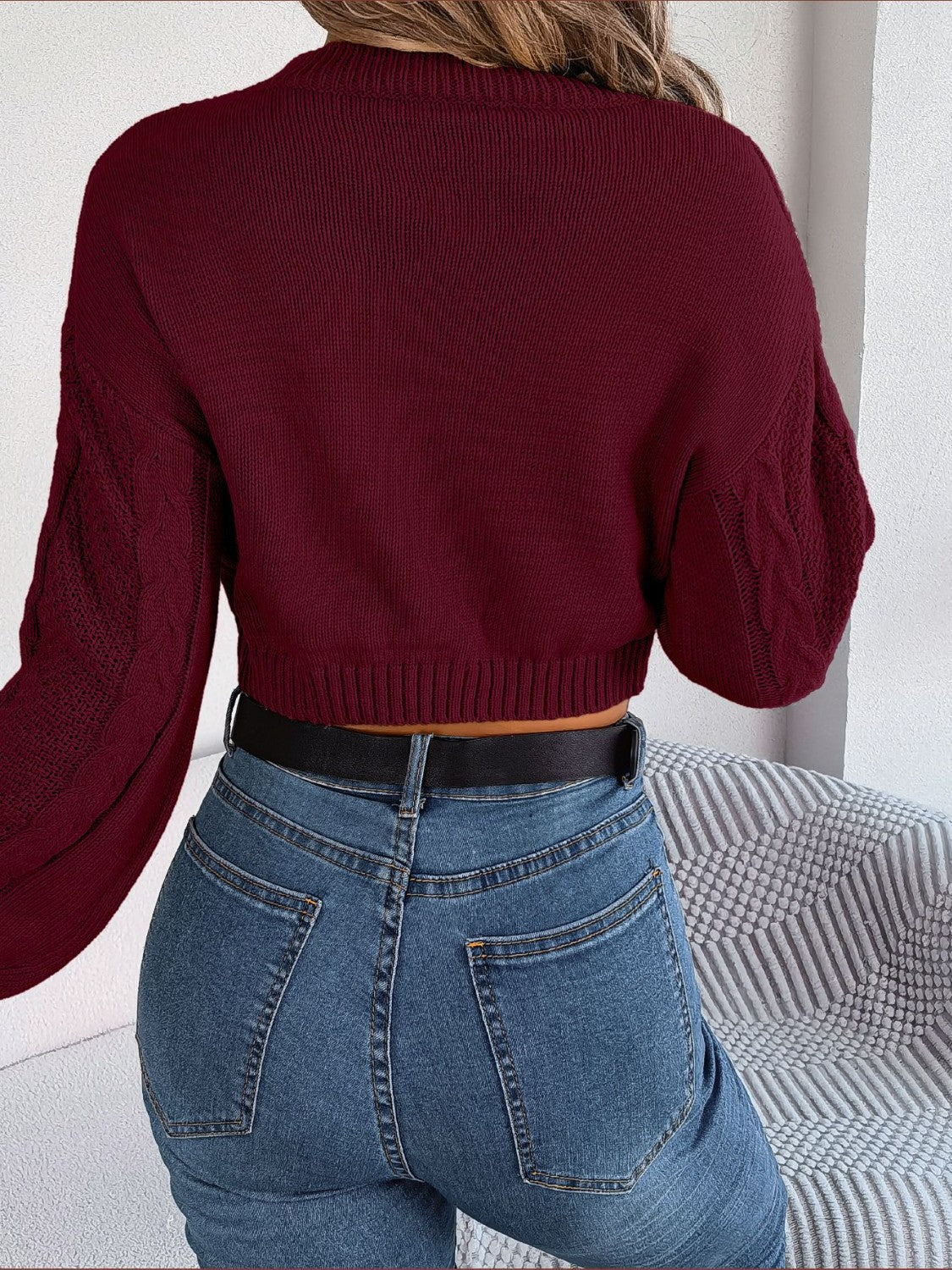 Wine cable knit cropped sweater with mock neck and textured sleeves.