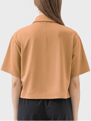 Cropped polo shirt in beige with short sleeves and a collar.