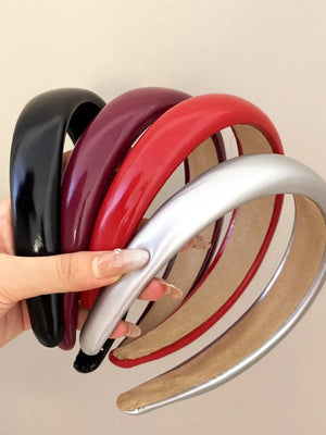 Glossy padded headbands in black, deep purple, deep red, and silver.