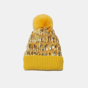 Metallic padded beanie with faux fur pom in gold and yellow ribbed cuff.