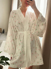 White cotton robe with pink floral print, tie waist, and wide sleeves.