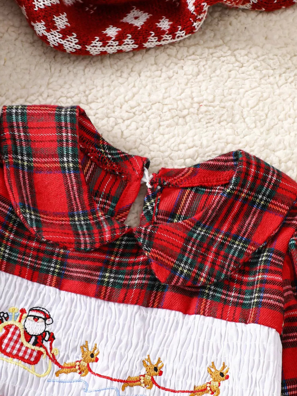 Baby dress with red plaid collar and smocked white bodice embroidered with Santa in a sleigh.