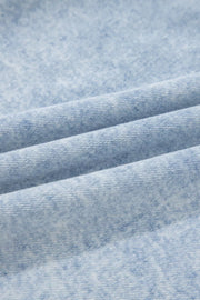 Light wash denim blouse with a textured, marbled pattern and visible weave.