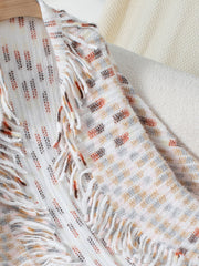 Textured fringe shawl cardigan in white with multi-color woven pattern and fringe details.