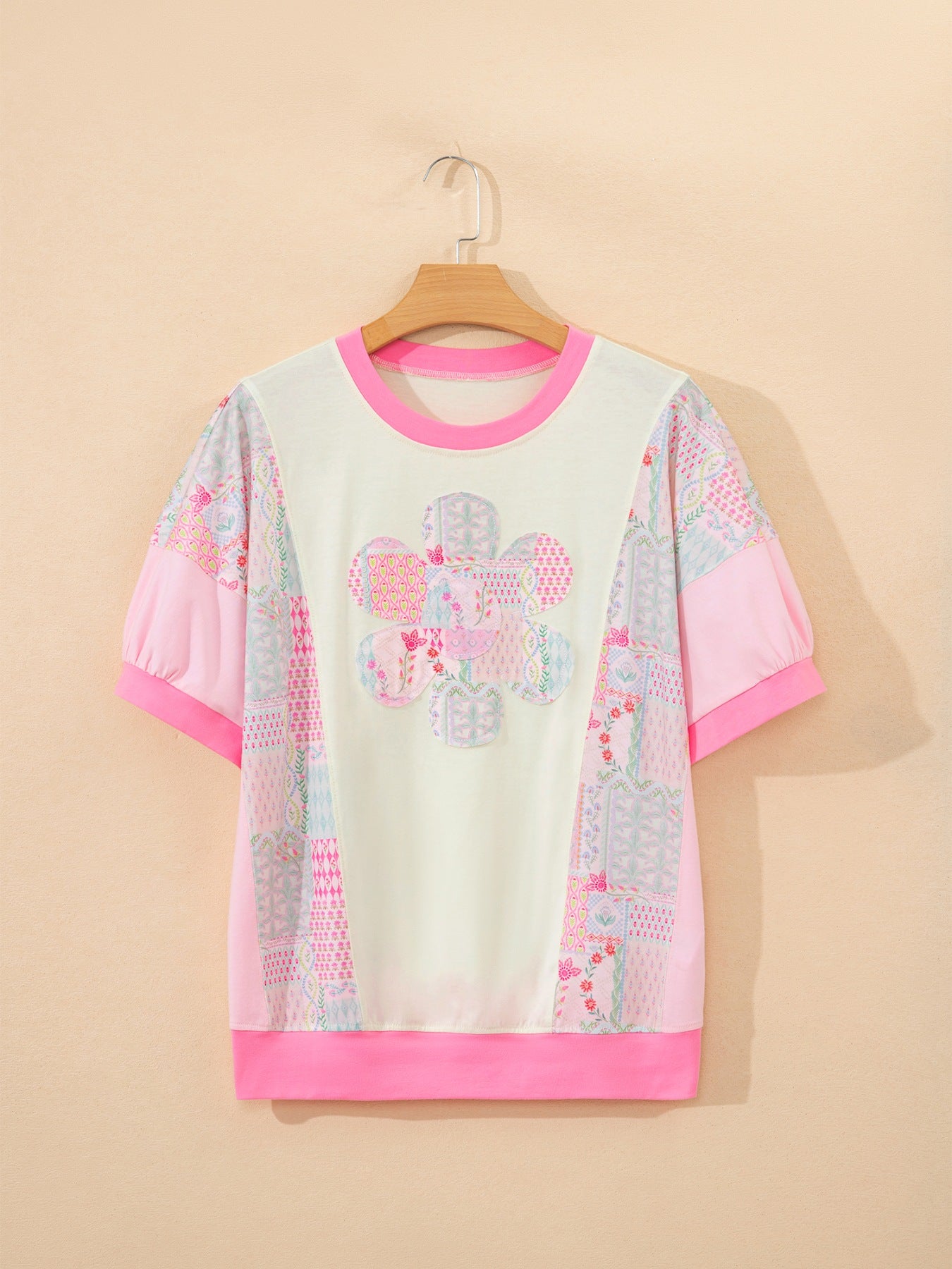 Maternity t-shirt with crew neck, short sleeves, floral patchwork pattern, and pink accents.