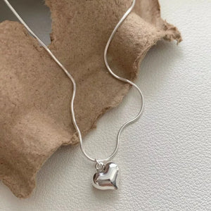 Sleek sterling silver heart pendant necklace with snake chain.