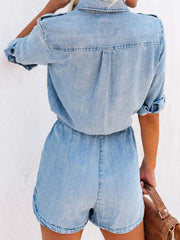 Light wash denim romper with shirred waist and buttoned short sleeves.