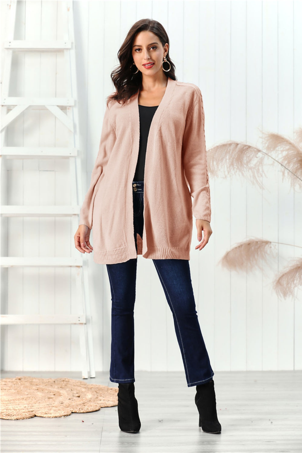 Apricot cable knit open front cardigan with textured sleeves.