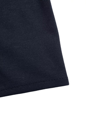 Dark navy vest detail showing textured fabric and hem stitching.