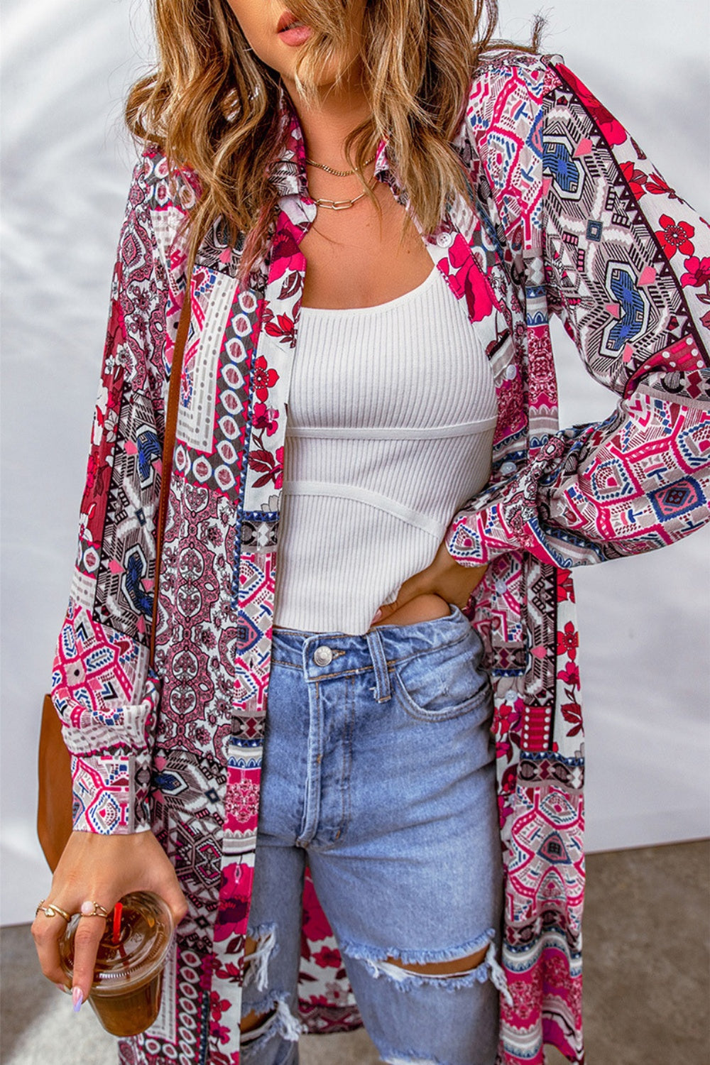 Patchwork print duster shirt jacket with button front and long sleeves, styled with a white tank and ripped jeans.