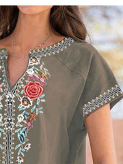 Army green blouse with floral embroidery and notched neckline.