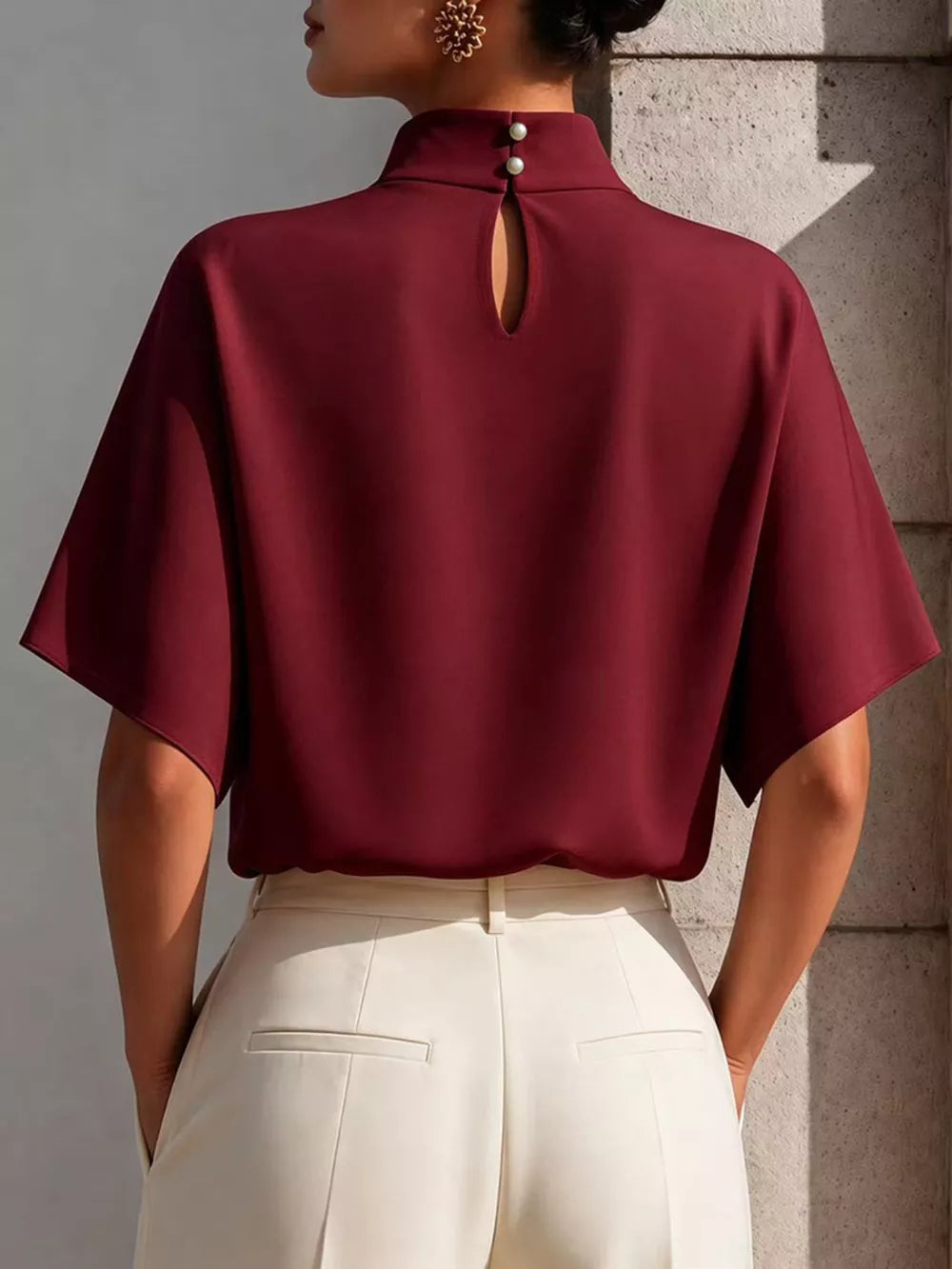 Burgundy mock neck t-shirt with relaxed sleeves, pearl button closure and keyhole detail.