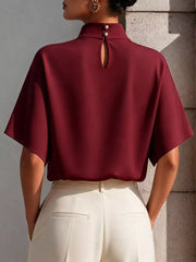 Burgundy mock neck t-shirt with relaxed sleeves, pearl button closure and keyhole detail.