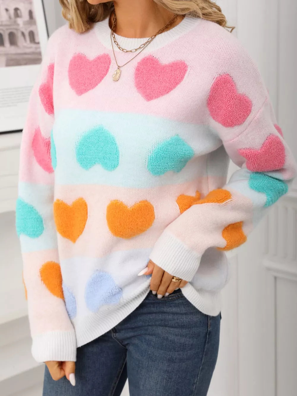 Fuzzy knit sweater with pastel heart pattern and color block stripes.