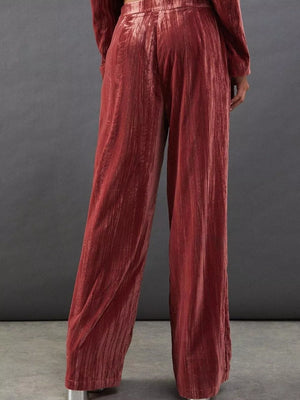 Burgundy velvet wide-leg trousers with a subtle ribbed texture, shown from the back.