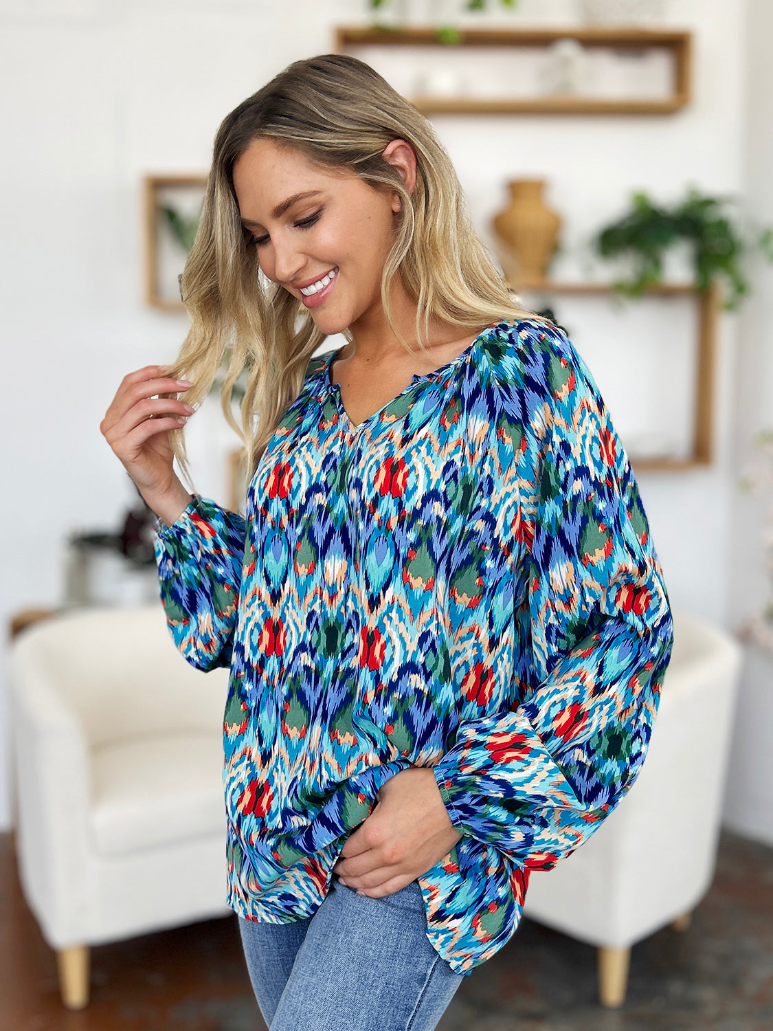 Prismatic ikat blouse with voluminous sleeves in blue and green with red accents.