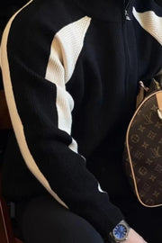 Black ribbed zip-up track jacket with white contrast panels on sleeves and chest.