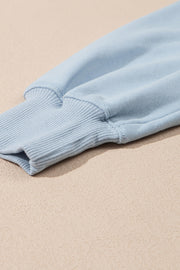 Light blue sweatshirt sleeve detail with ribbed cuff and stitching