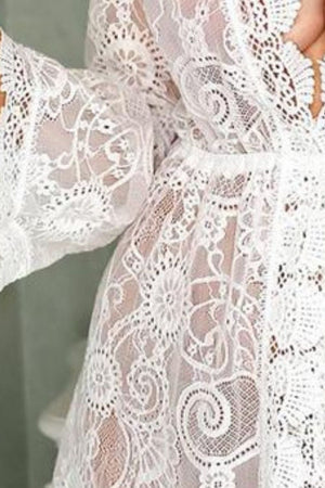 White lace bell sleeve cover-up with floral pattern and crochet details.