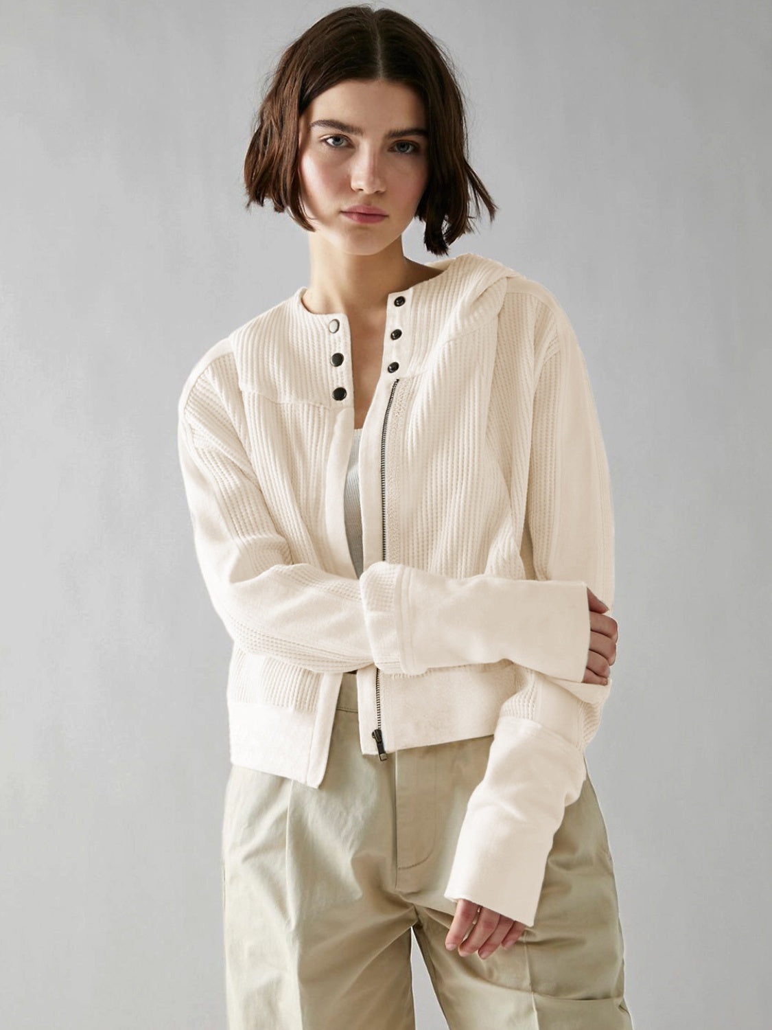 Cream waffle knit cropped hoodie with snap front and zipper detail.