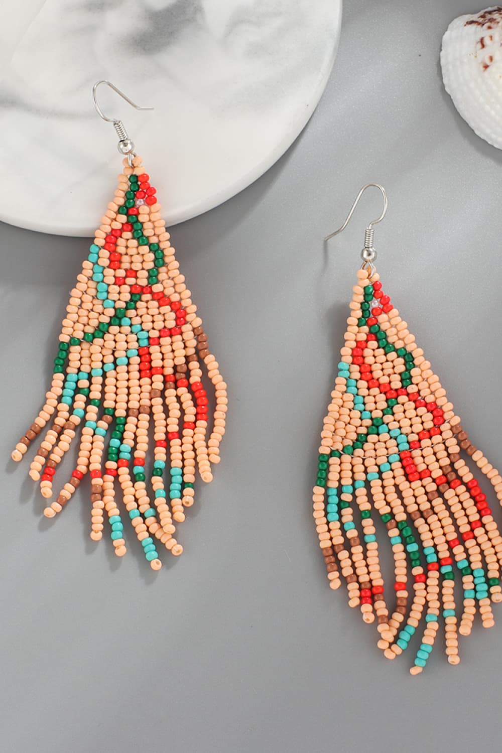 Beaded Christmas tree drop earrings with fringe in tan, red, green, and blue beads.