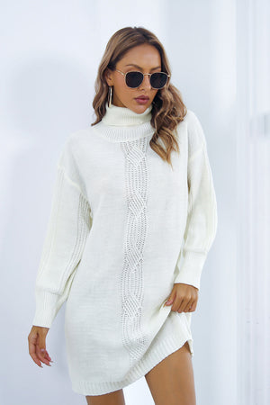 White cable knit turtleneck sweater dress with blouson sleeves and a relaxed fit.