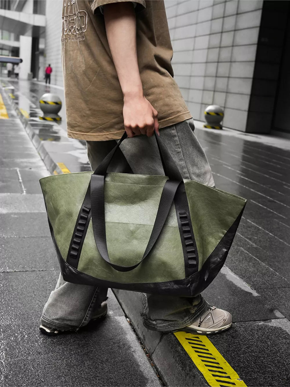 Green and black two-tone large capacity travel bag with black straps and black base.