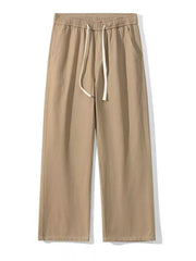 Khaki relaxed fit drawstring pants with elastic waist and white tie.