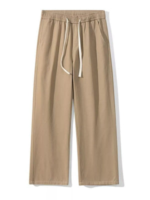Khaki relaxed fit drawstring pants with elastic waist and white tie.