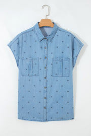 Light blue denim shirt with all-over dark star print, short sleeves, and two chest pockets.
